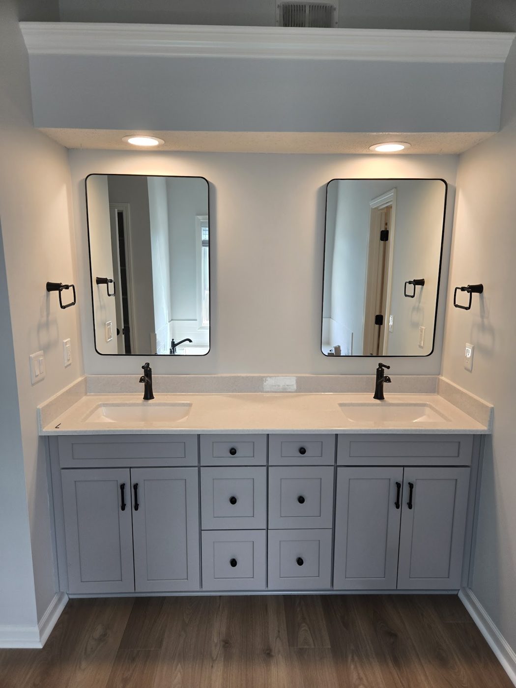 Double vanity remodel with two framed mirrors and shaker cabinets