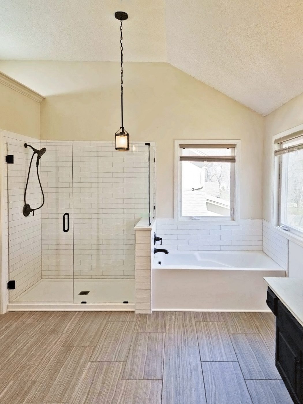 Finished bathroom with a glass shower, corner tub, and wood-look flooring